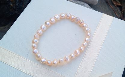 Jemný pružný náramek z pravých říčních perel ve světle lososové