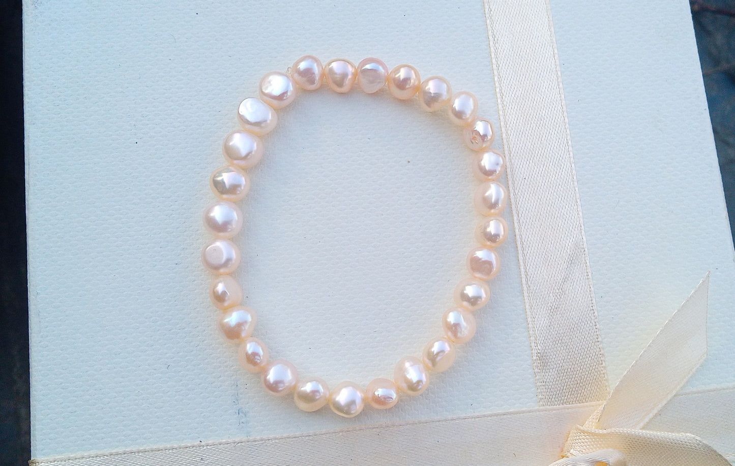 Jemný pružný náramek z pravých říčních perel ve světle lososové