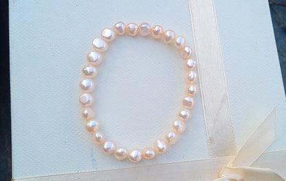 Jemný pružný náramek z pravých říčních perel ve světle lososové