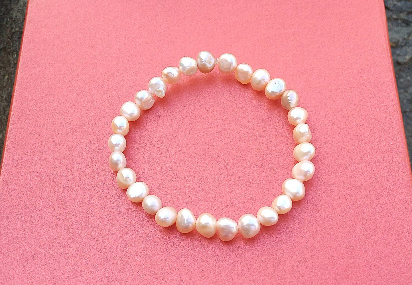 Jemný pružný náramek z pravých říčních perel ve světle lososové